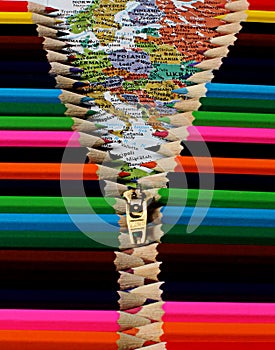 Conceptual art of colorful pencils being pulled down by a zipper revealing the world map in color