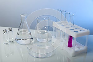 Conceptual background with chemical flasks. blue backdrop with lab glassware with copy space.