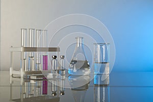 Conceptual background with chemical flasks. blue backdrop with lab glassware with copy space.