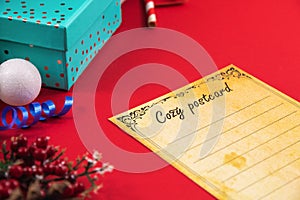 Conceptual christmas composition with postal cozy postcard with copy space on red background