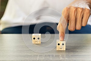 Conceptual the customer responded to the survey. The client using hand choose happy face smile icon on wood block. Depicts that