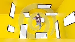 Conceptual design. Man with 3d mobile phone screens over yellowbackground. Online shopping and services. E-commerce