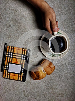 conceptual entertainment a glass of coffee two pieces of bread and work equipment on the table in the dining room