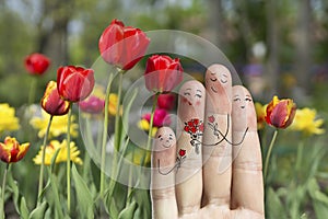 Conceptual family finger art. Father, son and daughter are giving flowers their mother. Stock Image