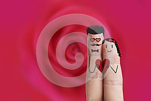 Conceptual finger art. Hipster Lovers are embracing and holding red heart. Stock