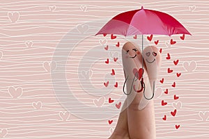 Conceptual finger art. Lovers are embracing and holding umbrella with falling hearts. Stock Image