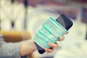 Conceptual of hand hold medical mask that cover smartphone / cell phone