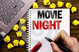Conceptual hand writing text caption Movie Night. Business concept for Wathing Movies Written on tablet laptop, wooden background