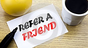 Conceptual hand writing text showing Refer A Friend. Business concept for Referral Marketing written sticky note empty paper, Wood