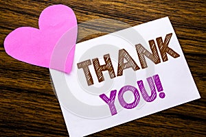 Conceptual hand writing text showing Thank You. Concept for Thanks Message written on sticky note paper, wooden wood background. W