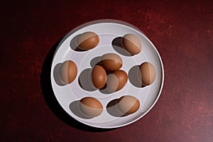 Conceptual image of 9 eggs in a white dish