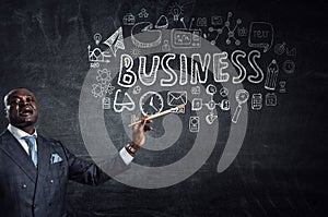 Conceptual image of ambitious and creative businessman in black suit holding paintbrush in hand