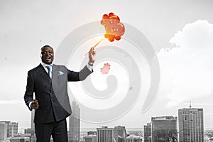 Conceptual image of ambitious and creative businessman in black suit holding paintbrush in hand