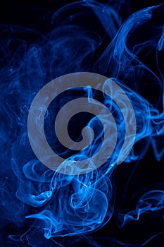 Conceptual image of blue color smoke isolated on dark black background