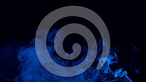 Conceptual image of blue color smoke isolated on dark black background, Halloween design