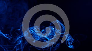 Conceptual image of blue color smoke isolated on dark black background, Halloween design