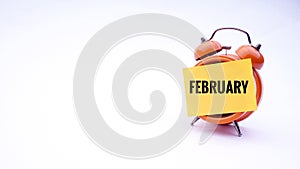 Conceptual image of Business Concept with words February on a clock with a white background. Selective focus.