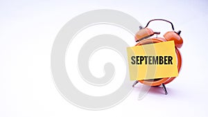 Conceptual image of Business Concept with words September on a clock with a white background. Selective focus.