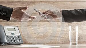 Conceptual image of Businessman Handing over a Pen to his Business Partner