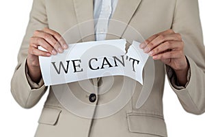 Conceptual image of businesswoman tearing a paper that reads we cant