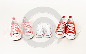 Family sneakers canvas shoes of two moms and child isolated on white in happy modern family concept