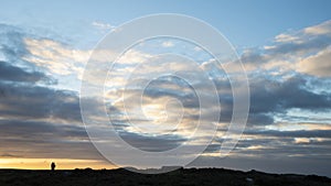 Conceptual image of isolation and remoteness with a couple silhoutted against large sky and minimal landscape