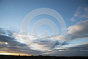 Conceptual image of isolation and remoteness with a couple silhoutted against large sky and minimal landscape