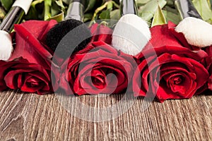 Conceptual image of make-up brushes next to roses