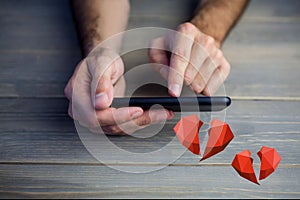 Conceptual image of man hands texting on mobile phone with digital generated red hearts
