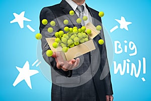 Conceptual image of man holding a box of tennis balls