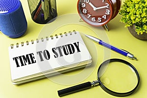 Conceptual image. paper note writing with alarm clock, vase, stationery, pen, magnifying glass and portable mini loud speaker