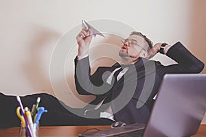Conceptual image: professional burnout, laziness, unwillingness to work. Portrait of slacker businessman sitting in office with photo