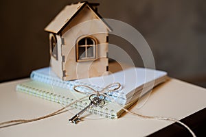 Conceptual image with small wooden house and keys