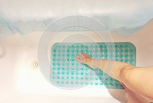 Conceptual image of taking safety precaution using an anti-slip in bathtub to prevent accidents