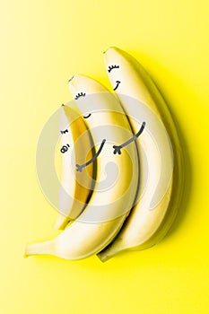 Conceptual image of two big banana parents holding a small baby banana