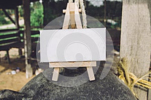 conceptual image white canvas and wooden easel on black buoy