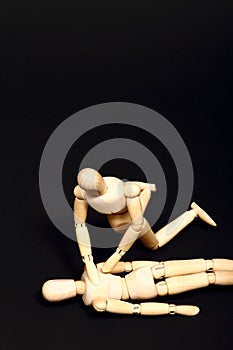 Conceptual image of wooden manikins administering CPR