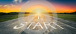 Conceptual image with word start on asphalt road at sunset.