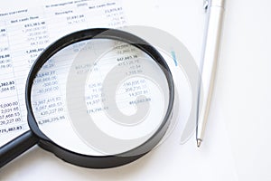 Conceptual Magnifying Glass on Top of Sales Invoice Reports, Emphasizing Scrutinizing Figures