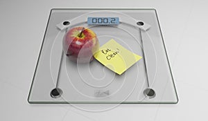 Conceptual and modern still life delicious apple and yellow posit note text saying eat clean stuck on bathroom scale in weight photo
