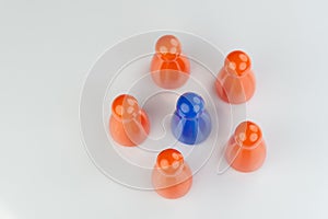 Conceptual orange game pawns and a blue play pawn