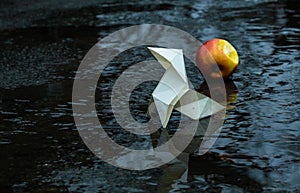 Origami paper figure on the background of a gloomy city street and puddles photo