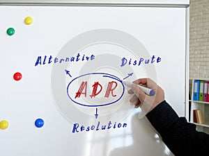 Conceptual photo about ADR Alternative Dispute Resolution . Male hand with marker write on the white board