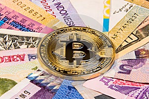 Conceptual photo of bitcoin internationalism. Physical coin bitcoin on the banknotes of different countries.