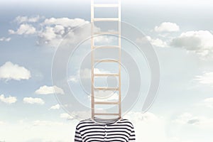 A conceptual photo with a ladder coming out of a person`s body and climbing towards a cloudy sky