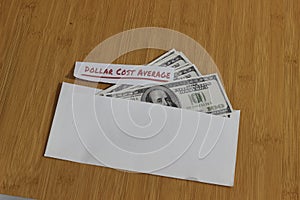 Conceptual Photo, money paper inside white Envelope and text Dollar Cost Average, or DCA golden rule investment