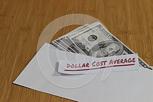 Conceptual Photo, money paper inside white Envelope and text Dollar Cost Average, or DCA golden rule investment