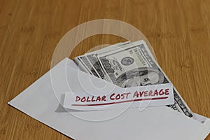 Conceptual Photo, money paper inside white Envelope and text Dollar Cost Average, or DCA golden rule investment