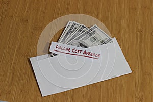 Conceptual Photo, money paper inside white Envelope and text Dollar Cost Average, or DCA golden rule investment