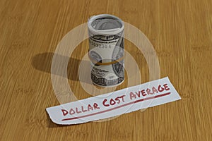 Conceptual Photo, money paper tight by Rubber Band and text Dollar Cost Average, or DCA golden rule investment